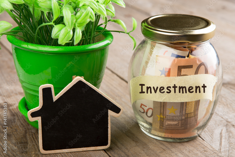 Real estate finance concept - money glass with investment word Real estate finance concept - money glass with investment word