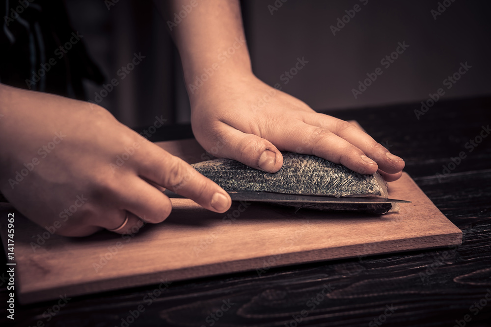 Fototapeta premium Chef cutting the fish on a board