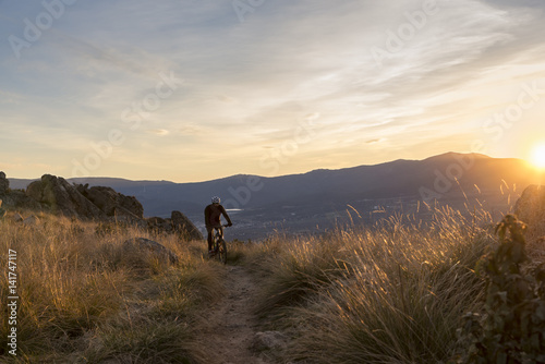 Cyclist on the mountain at sunset