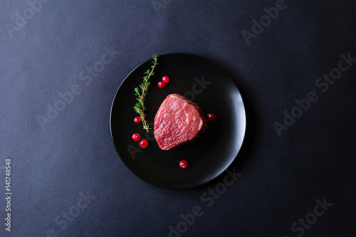Raw meat on black plate and dark background