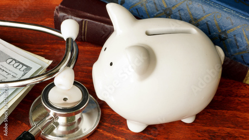 Stethoscope, piggy bank and cash. Affordable health care concept. photo