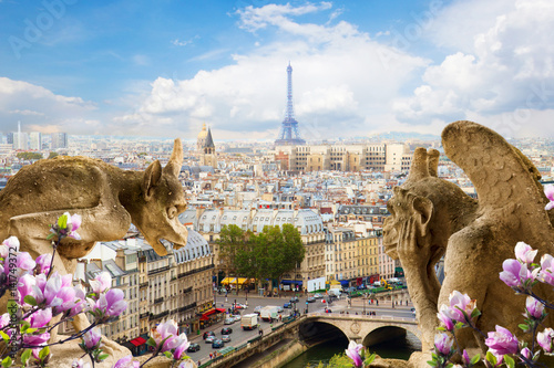 Gargoyle on Notre Dame Cathedral and city of Paris with spring flowers, France