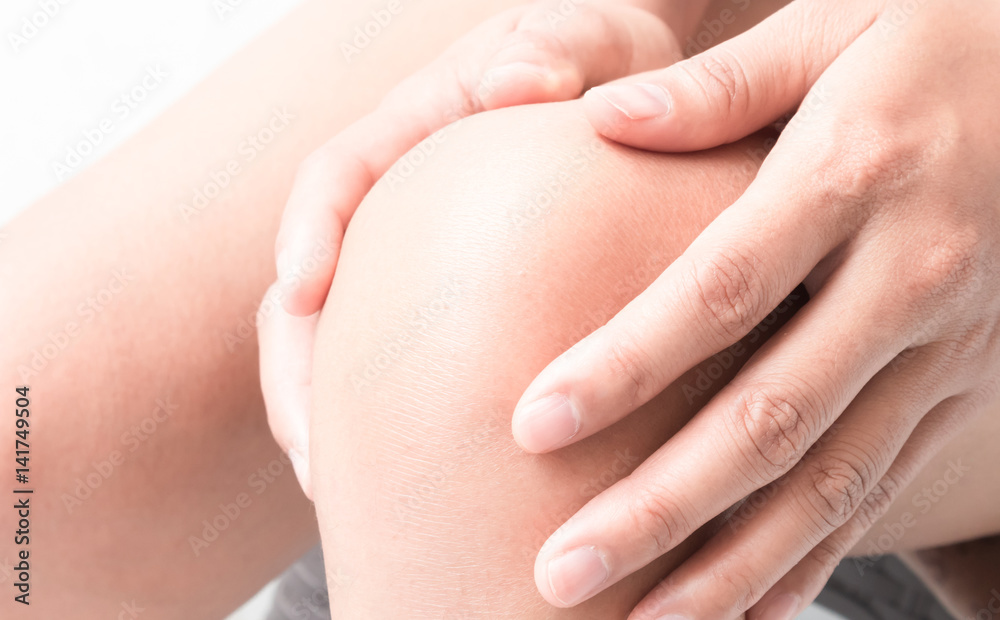 Closeup woman hand hold knee with pain symptom, health care and medicine concept Closeup woman hand hold knee with pain symptom, health care and medicine concept