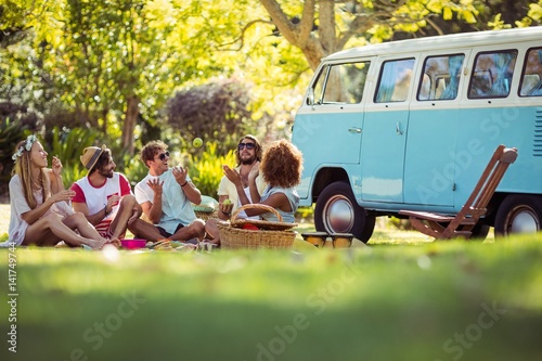 Fotografija Group of friends having fun together near campervan