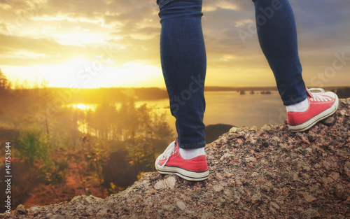 Legs of traveler standing on the cliff. Travel and freedom concept