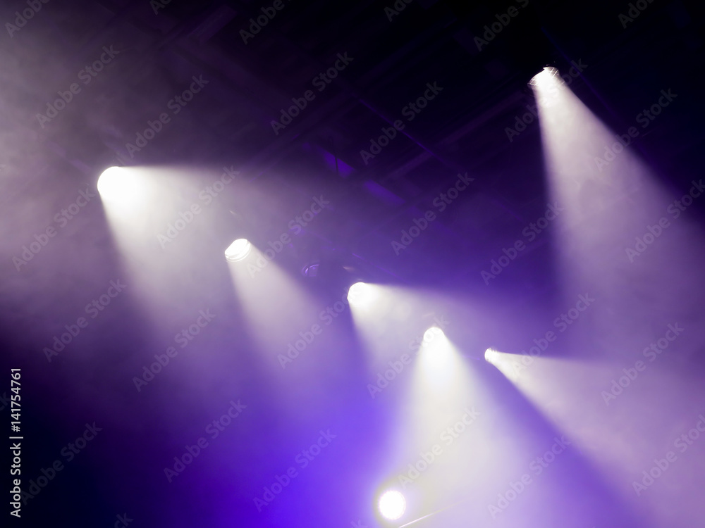 The light rays from the spotlight through the smoke. Lighting equipment on the ceiling. The stage of a theatre or night club. Show or performance. The light rays from the spotlight through the smoke. Lighting equipment on the ceiling. The stage of a theatre or night club. Show or performance.