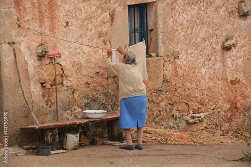 anciana tendiendo ropa