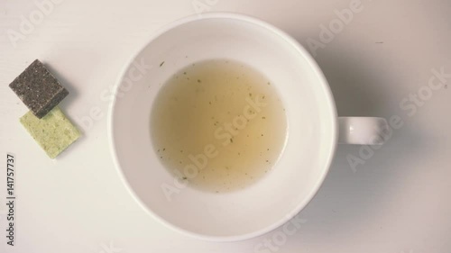 Hot chicken clear soup is poured into the soup ladle in a soup bowl, from bouillon cubes. Top view