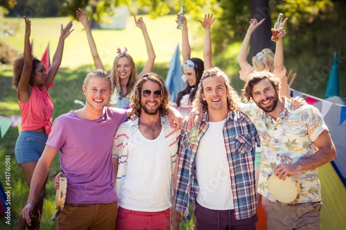 Happy friends posing together at campsite