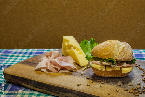 Fresh baked sandwich panini filled with ham, cheese and salad