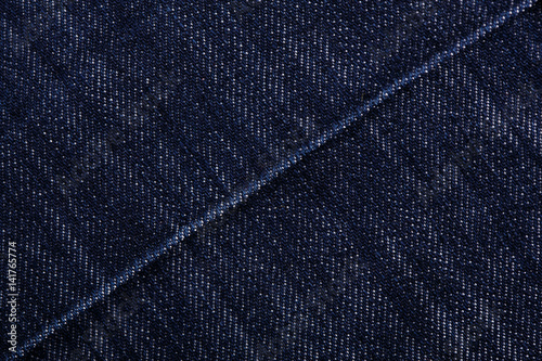 Denim jeans texture background with torn. The texture of the colored cotton fabric. Stitched texture jeans background. Fashion jeans button. Pocket and rivet on jeans. Fiber and fabric structure. © stas_malyarevsky