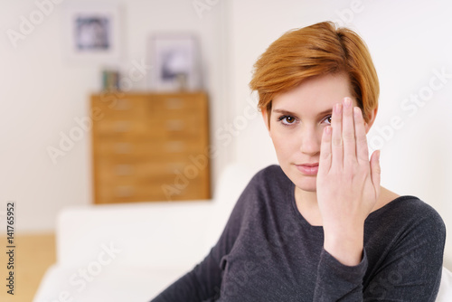 schöne frau hält eine hand vor ihr gesicht