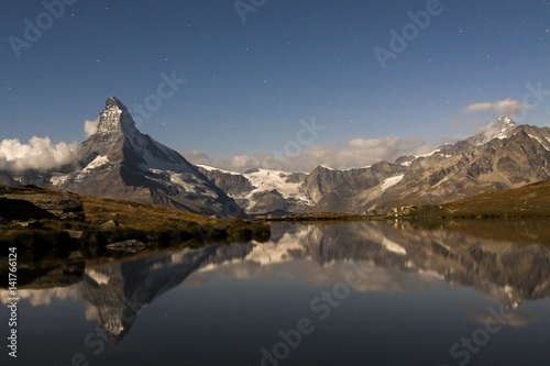 The Matterhorn reflected in lake Stellissee on a starry night in summer,Zermatt valley, Valais-Wallis Canton, Switzerland photo