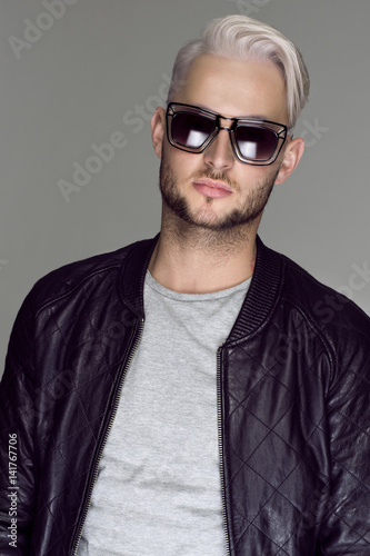 Young handsome sexy bearded man in leather jacket and sunglasses.