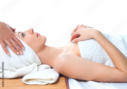 beautiful young woman having massage in spa lying on table