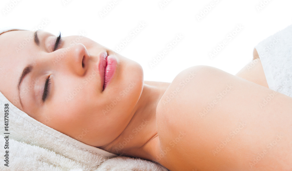 beautiful woman with closed eyes lying on table in spa