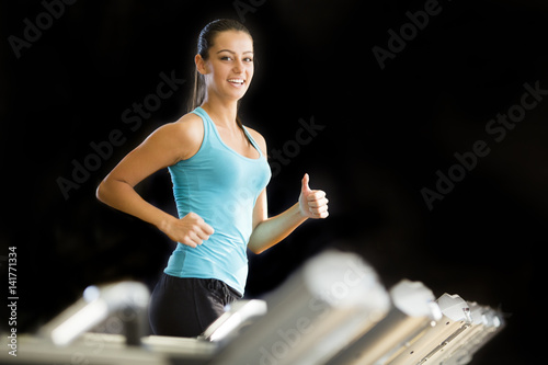 Young woman exercise on the treadmill at the gym photo