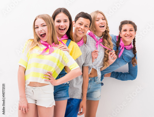 cute teenage children standing one by one holding each other