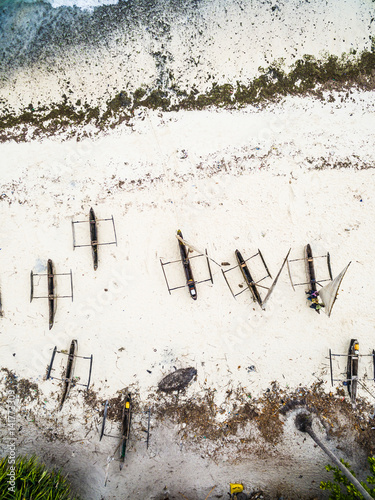 many wooden fishing boats on african seashore, top view, aerial photo