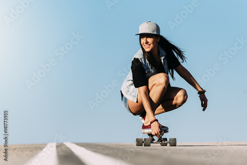 Beautiful skater woman riding on her longboard. photo