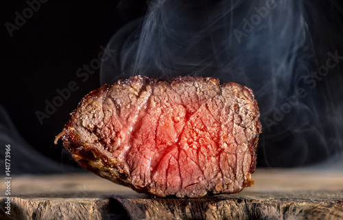 ein saftiges, kurz gebratenes Stück Rindfleisch vor schwarzem Hintergrund