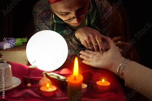 Cuadro en lienzo Fortune teller woman holding another woman hand for palm reading