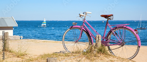 Vélo rose devant la plage