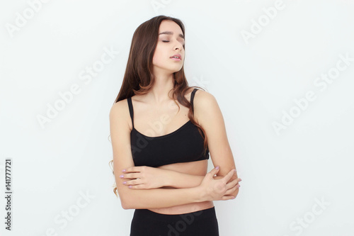 Beautiful girl in black top on white background shows emotion