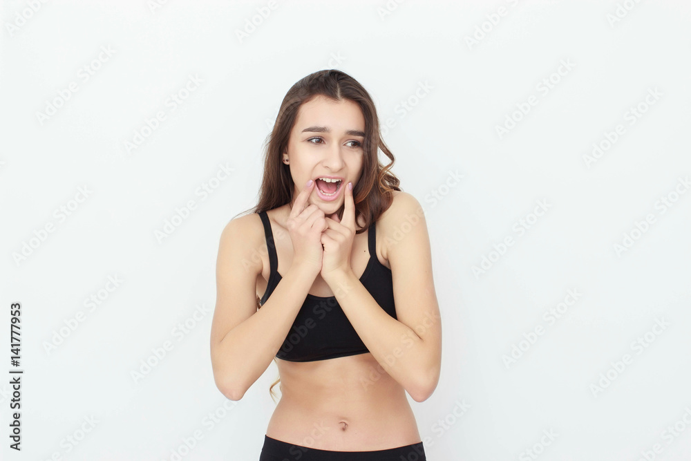 Fototapeta premium Beautiful girl in black top on white background shows emotion
