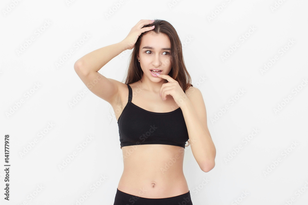 Beautiful girl in black top on white background shows emotion
