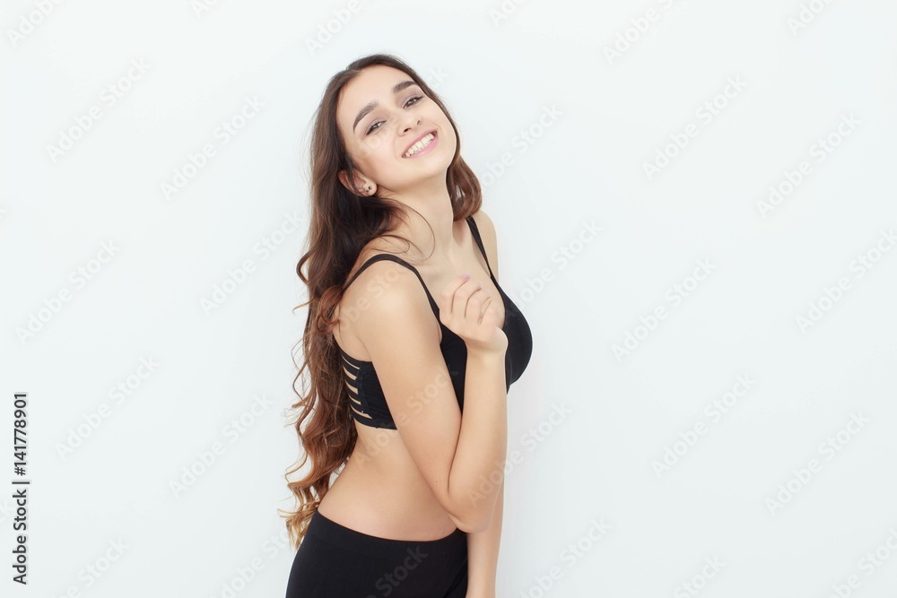 Beautiful girl in black top on white background shows emotion