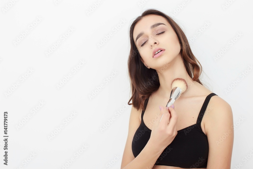Portrait of beautiful woman applying a cosmetic isolated on beige