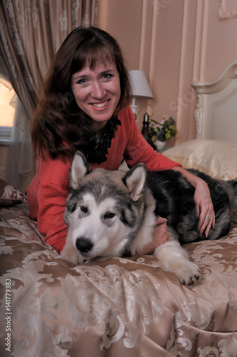 The girl together with huskies at home
