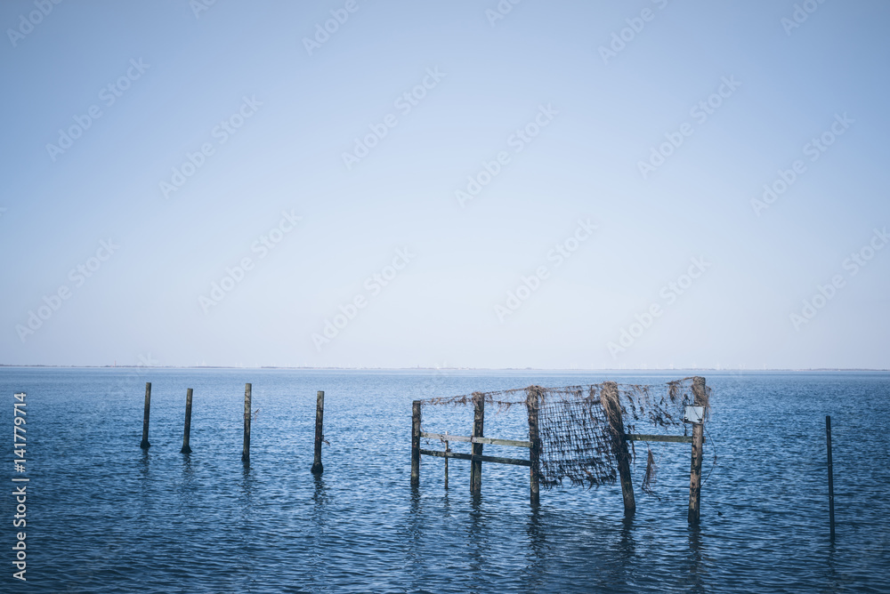 wooden posts poles in blue sea