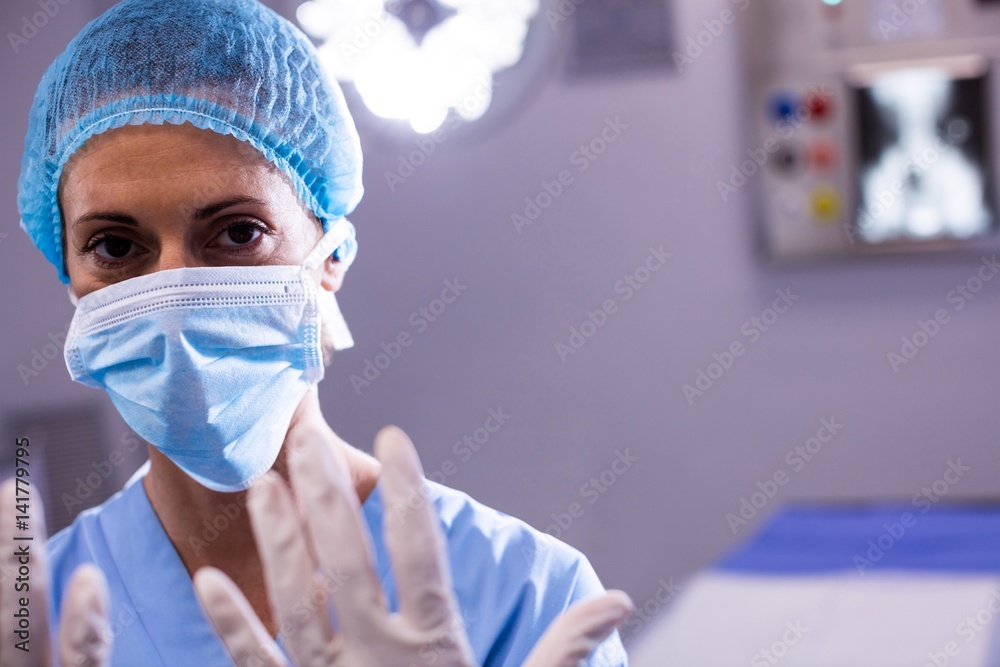 Portrait of female surgeon preparing for operation in operation room Portrait of female surgeon preparing for operation in operation room
