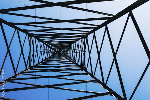 High voltage power pylons against blue sky. Transmission power line.
