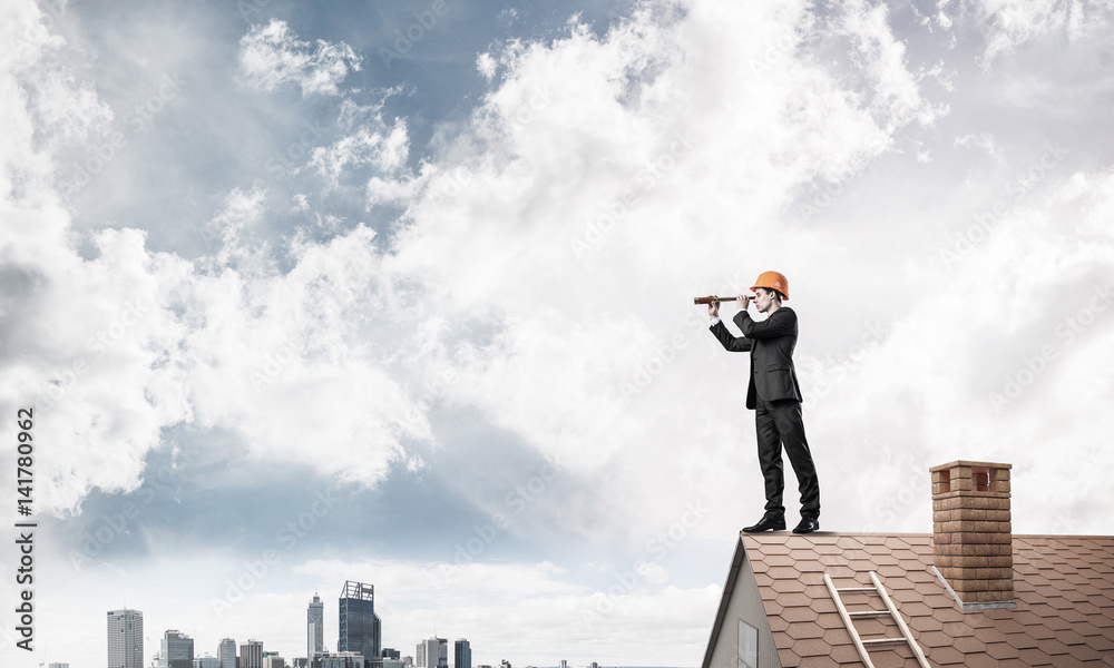 Engineer man standing on roof and looking in spyglass. Mixed med Engineer man standing on roof and looking in spyglass. Mixed med