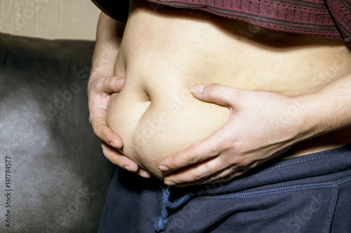 Full woman supports hands your fat belly