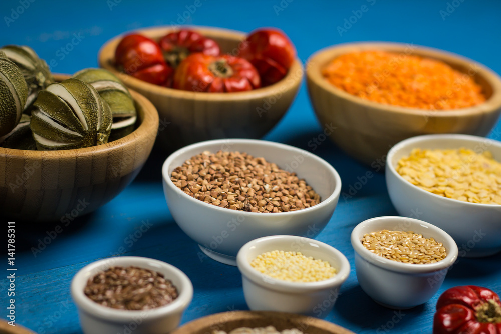 Bowls and spoons of various legumes on wooden table Bowls and spoons of various legumes on wooden table