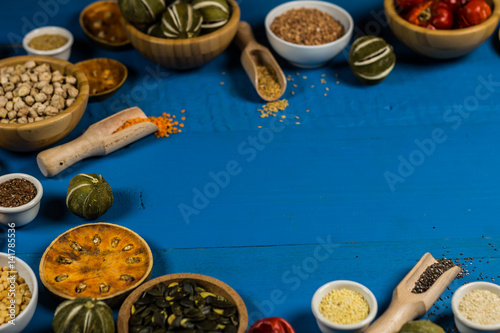 Bowls and spoons of various legumes on wooden table