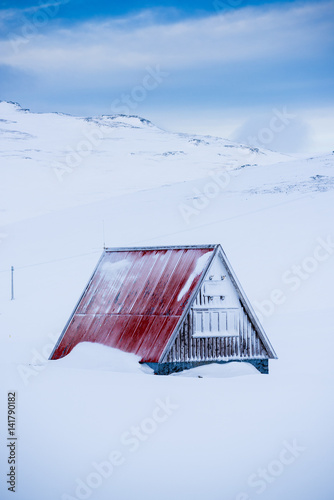 Snaefellsness peninsula, Western Iceland, Europe. A little house with sloping roof surrounded by snow in winter.