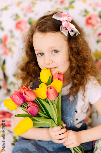 Portrait of litlle girl holding tulips bouquet