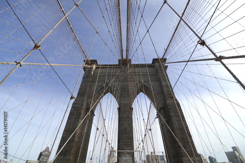 Fototapeta Naklejka Na Ścianę i Meble -  Perfectly geometric view of Brooklyn Bridge in NYC with overview on Manhattan skyline