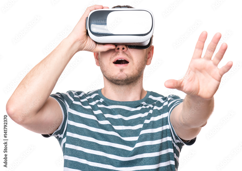 Naklejka premium Amazed man wearing virtual reality goggles watching movies or playing video games, isolated on white background. Surprised male looking in VR glasses. People experiencing 3D gadget technology.