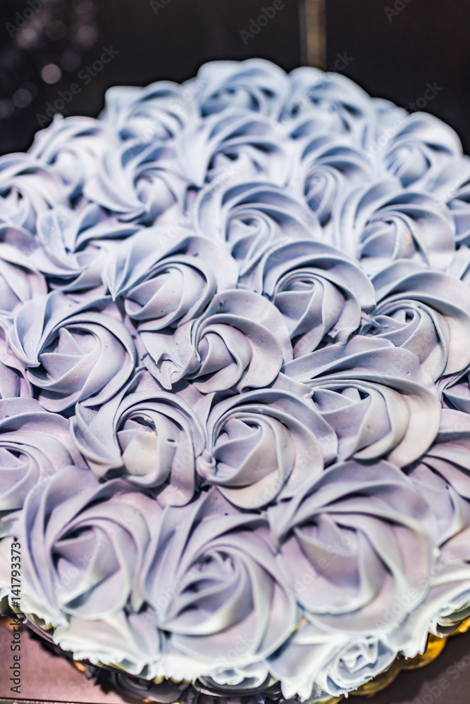 Lavender rose piped frosting iced large cake on display in bakery Lavender rose piped frosting iced large cake on display in bakery