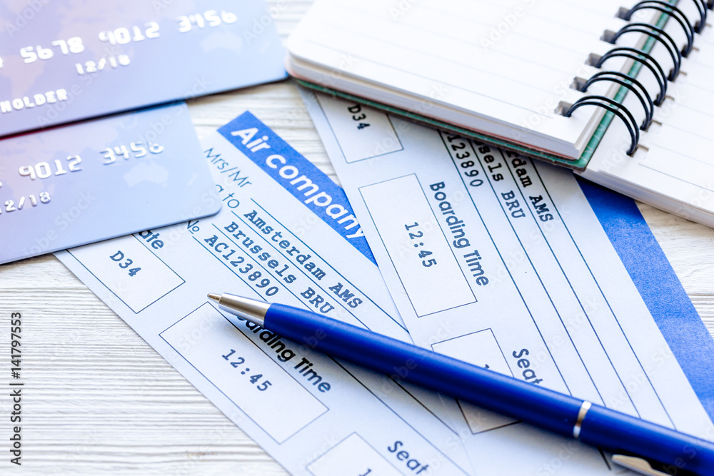 Buying airline tickets online with credit cards on table background Buying airline tickets online with credit cards on table background