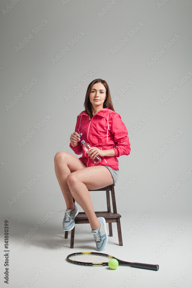 Young woman relaxing after tennis training. Young woman relaxing after tennis training.