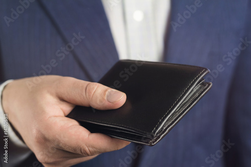 Business man hold in his hand leather wallet.