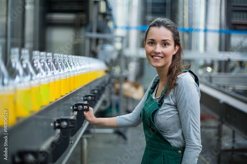 Tableau sur toile Female factory worker standing near production line