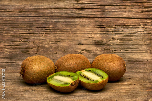 Fresh Group of Kiwi Fruits Full and Sliced on Wood Table Background, Rustic